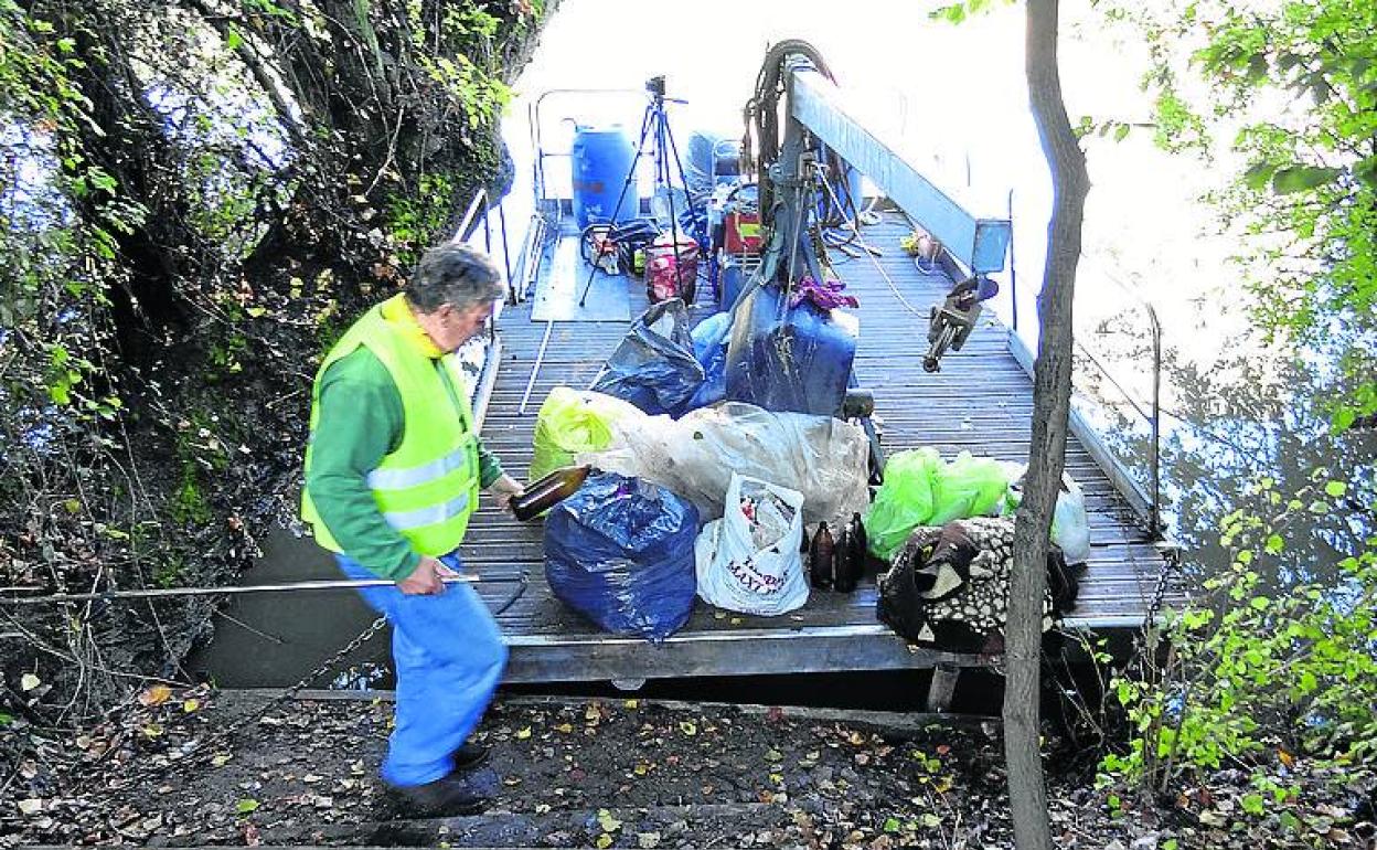 Luis Ángel Largo retira en la balsa la basura recogida. 