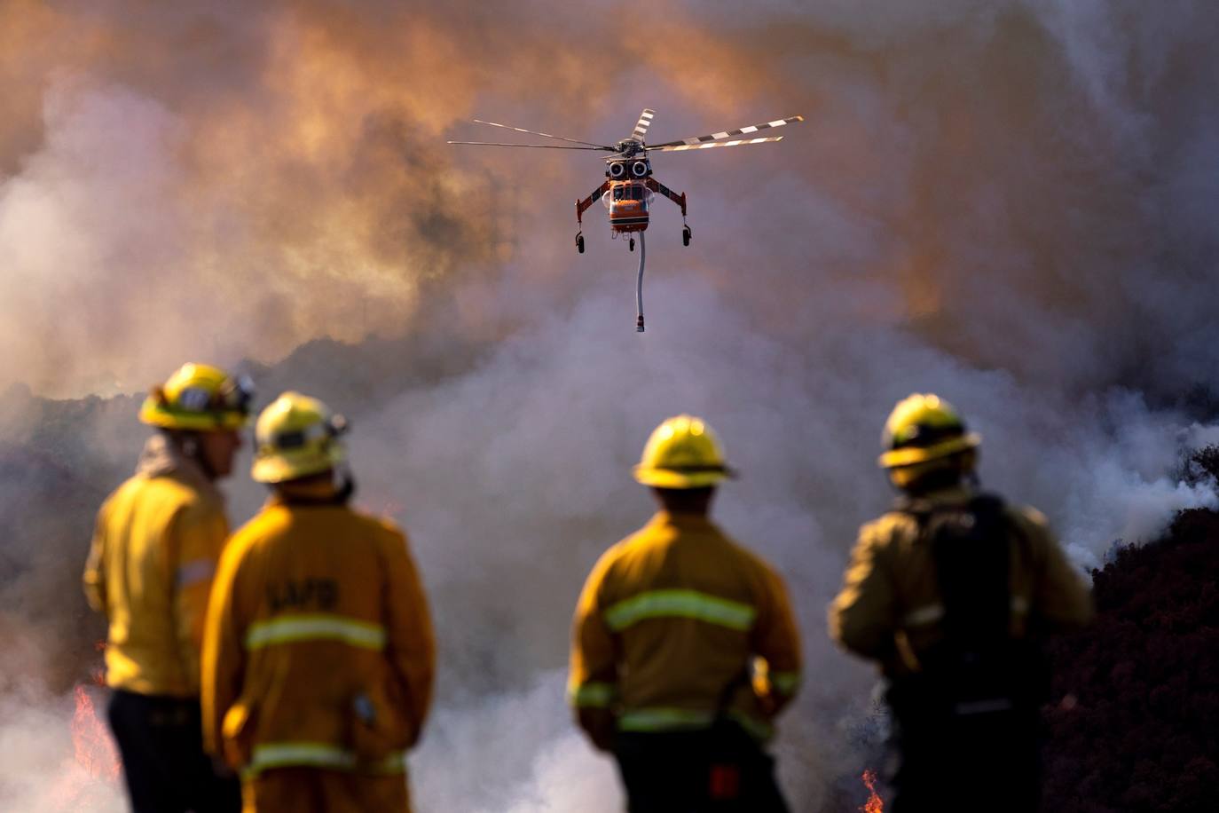 Bomberos observan helicópteros que arrojan agua sobre el llamado 'Getty Fire' cerca del famoso museo Getty Center en Los Ángeles