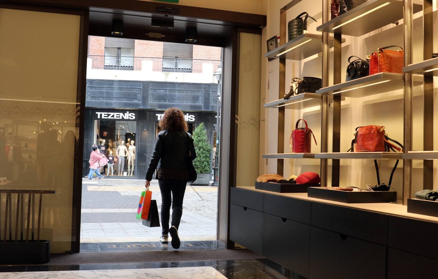 Una cliente sale de uno de los comercios de la calle Santiago. 