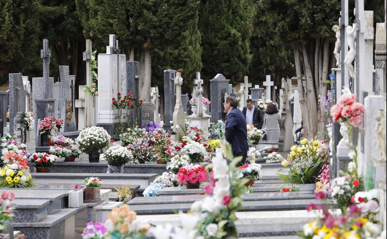 Varias personas honran a sus muertos en el cementerio de Palencia.