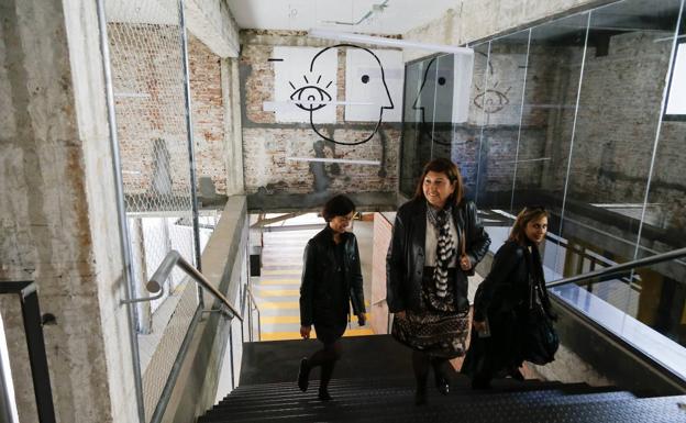 Imagen principal - Victoria Soto visita las instalaciones con miembros de su equipo. Debajo, una de las sala de reuniones del nuevo centro. A la derecha, uno de los grafitis del espacio polivalente.