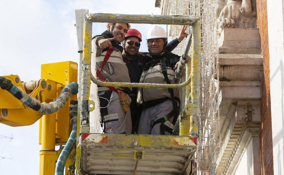 Trabajadores de Iluminaciones Ximénez terminando de instalar las luces navideñas en la fachada del Ayuntamiento de Valladolid. 