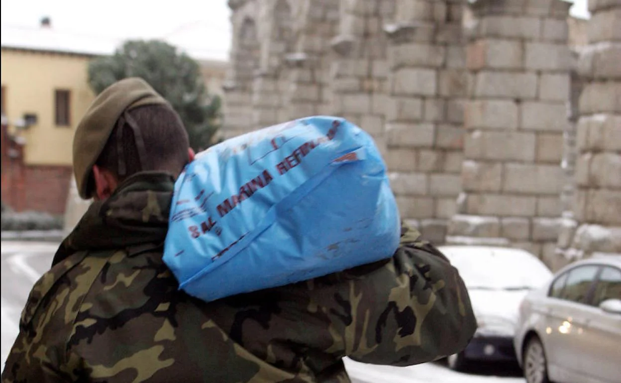 Un militar carga un saco de sal en un episodio de nevadas.