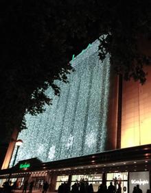 Imagen secundaria 2 - Coral Ciudad de Valladolid y fachada iluminada en el Corte Inglés de Constitución. En la tercera foto, iluminación navideña del centro del Paseo de Zorrilla. 