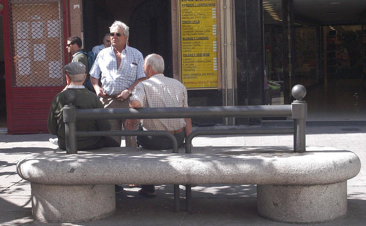 Unos jubilados conversan en la calle. 