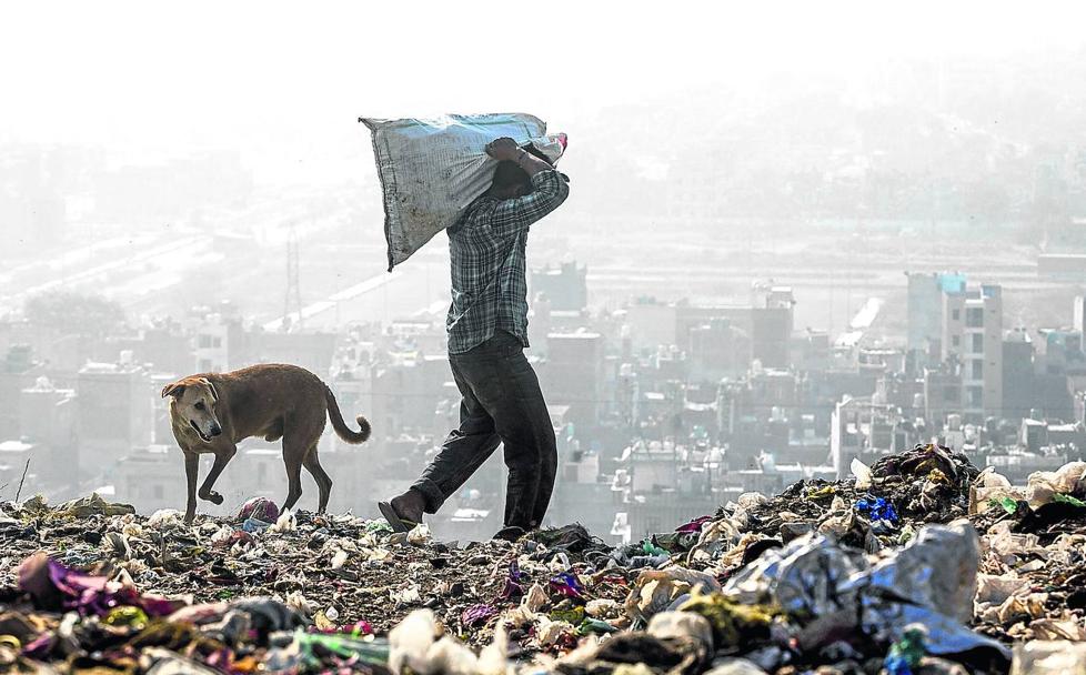 Un hombre rescata material en un vertedero de Nueva Delhi, la ciudad más tóxica del planeta.