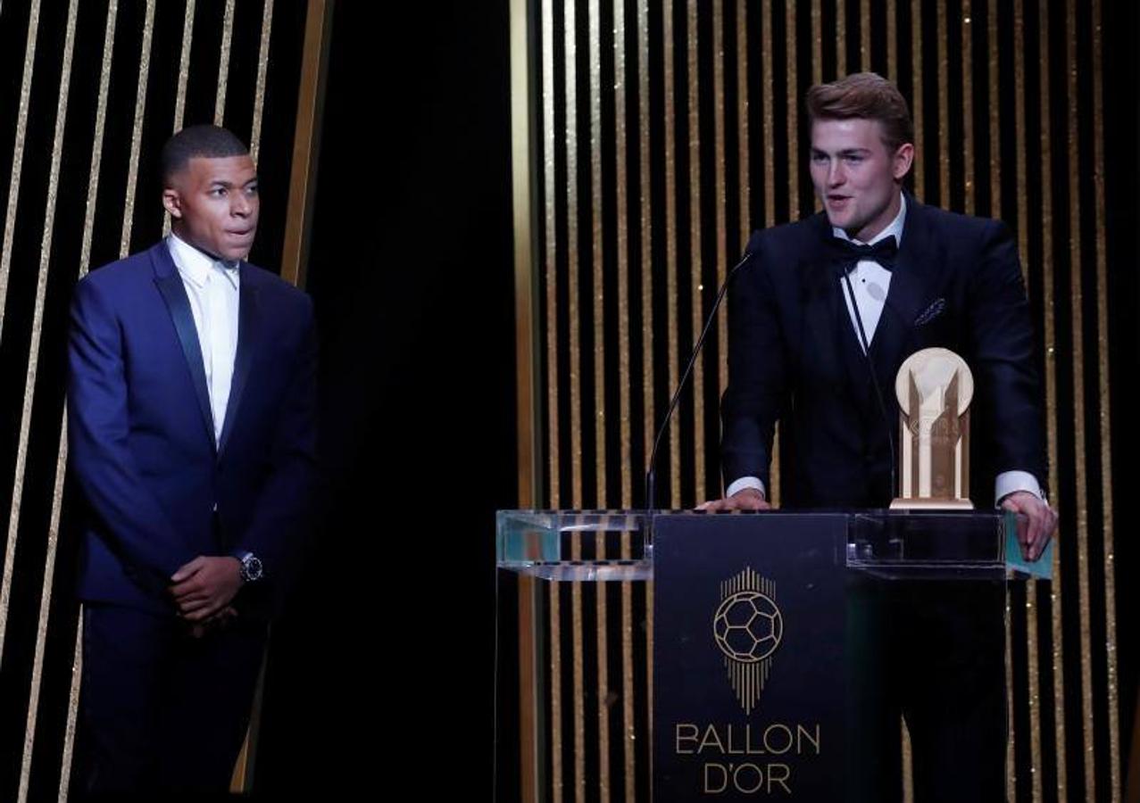 Matthijs De Ligt recogiendo el Trofeo Kopa bajo la mirada de Kylian Mbappé.