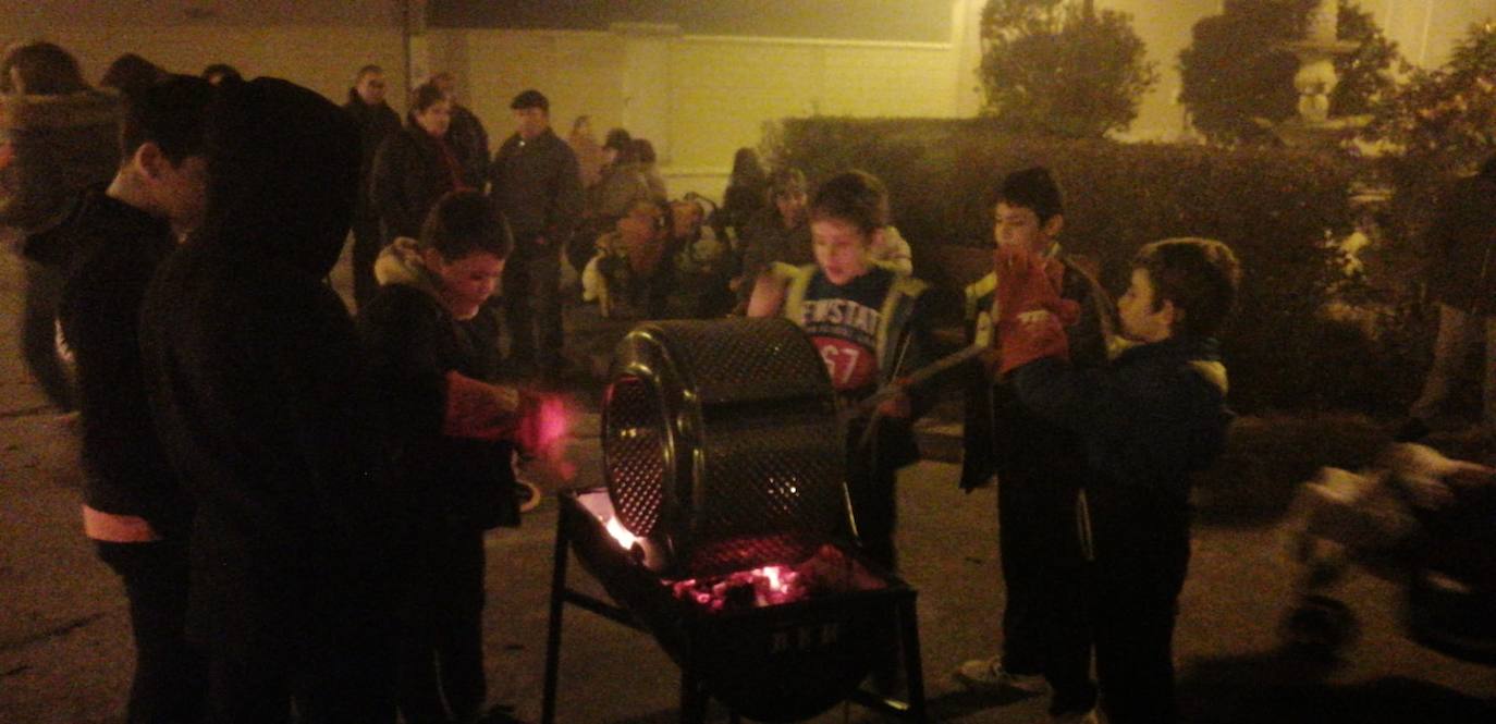 Los niños asando las castañas en el día festivo. 