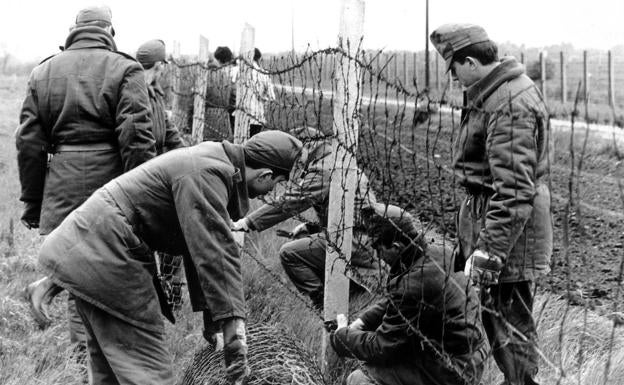 Soldados húngaros retiran la alambrada de espino de la frontera con Austria, cerca de Hegyeshalom, a 50 kilómetros de Viena, en mayo de 1989. 