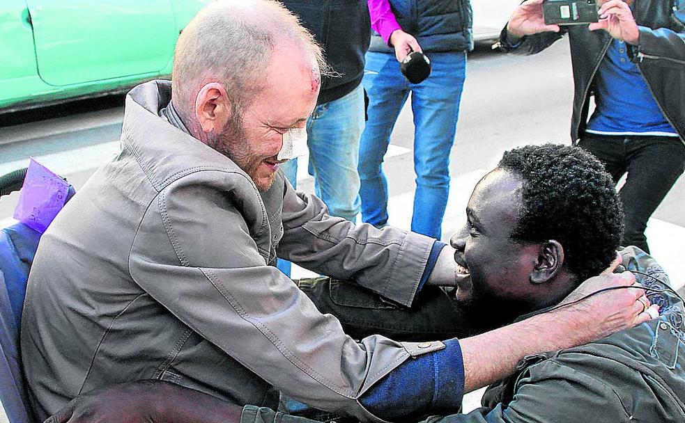 Álex Caudeli, en silla de ruedas, agradece a su rescatador, Gorgui Lamine, su ayuda.