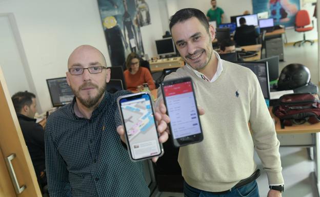 Sergio Morales y José Antonio Gallego, dos de los tres fundadores junto a Víctor Ortega, muestran la app de los aeropuertos escoceses. 