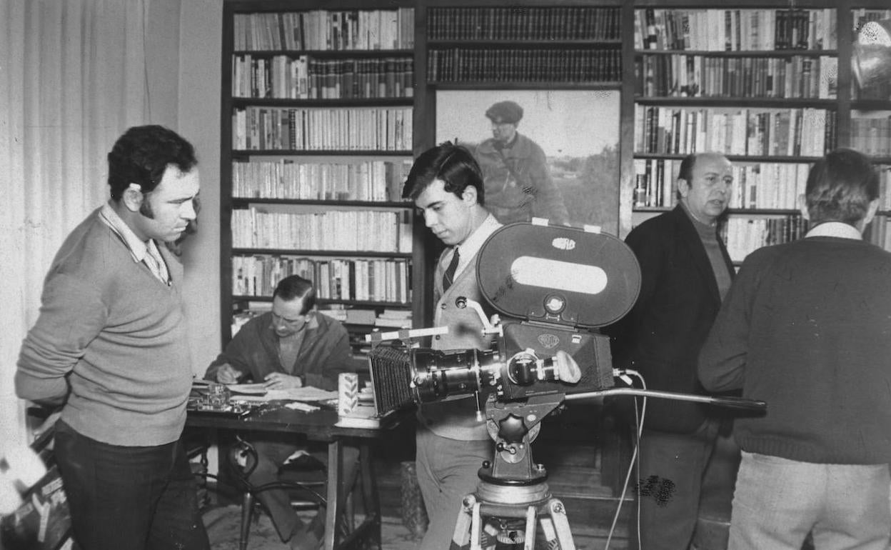 Miguel Delibes, sentado al fondo, en su despacho durante la grabación de un reportaje de televisión en torno a su obra en los años 70.