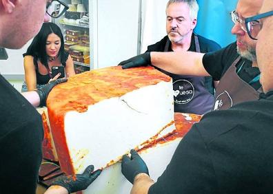 Imagen secundaria 1 - Feria 'Cheese Naturales e Possible'. Los quesos canarios debutaron en este certamen italiano con uno de 135 kilos elaborado por la quesería grancanaria Bolaños. En la fotografía, el proceso de corte.