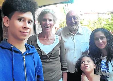 Imagen secundaria 1 - Alaa Eddin, Laura y Pablo, de Madrid, charlan durante una convivencia; Kevin (izquierda) posa con Assun, Lolo y su familia, Rebeca y Gladys y en la última fotografía, la tarjeta roja que reconoce como solicitante de asilo.