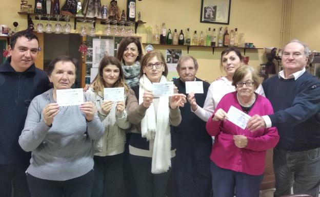 Varios vecinos de Robladillo en el Centro Cultural San Pelayo posan con las papeletas premiadas.