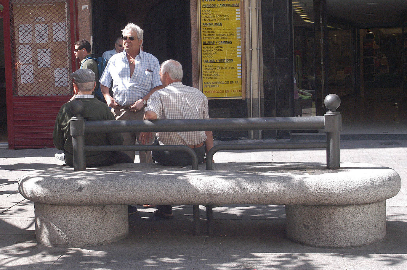 Unos jubilados charlando en un banco.