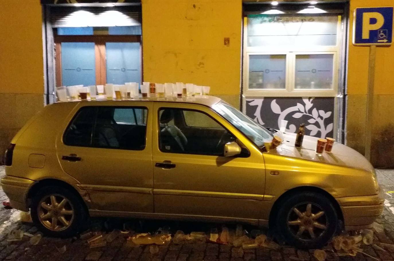 Decenas de vasos apoyados en un coche aparcado en la calle de los bares tras la celebración de la Tardebuena.