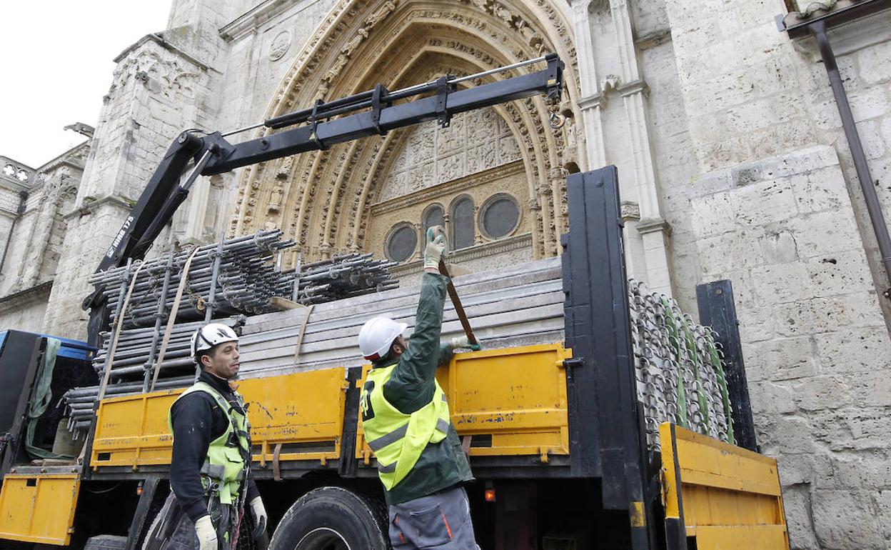 Dos trabajadores guardan en un camión los andamios instalados en la catedral para su restauración. 