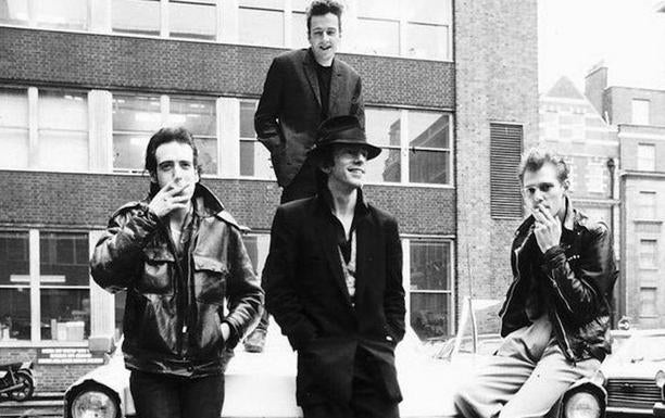 Joe Strummer –subido encima del coche–, Paul Simonon, Topper Headon y Mick Jones, The Clash.