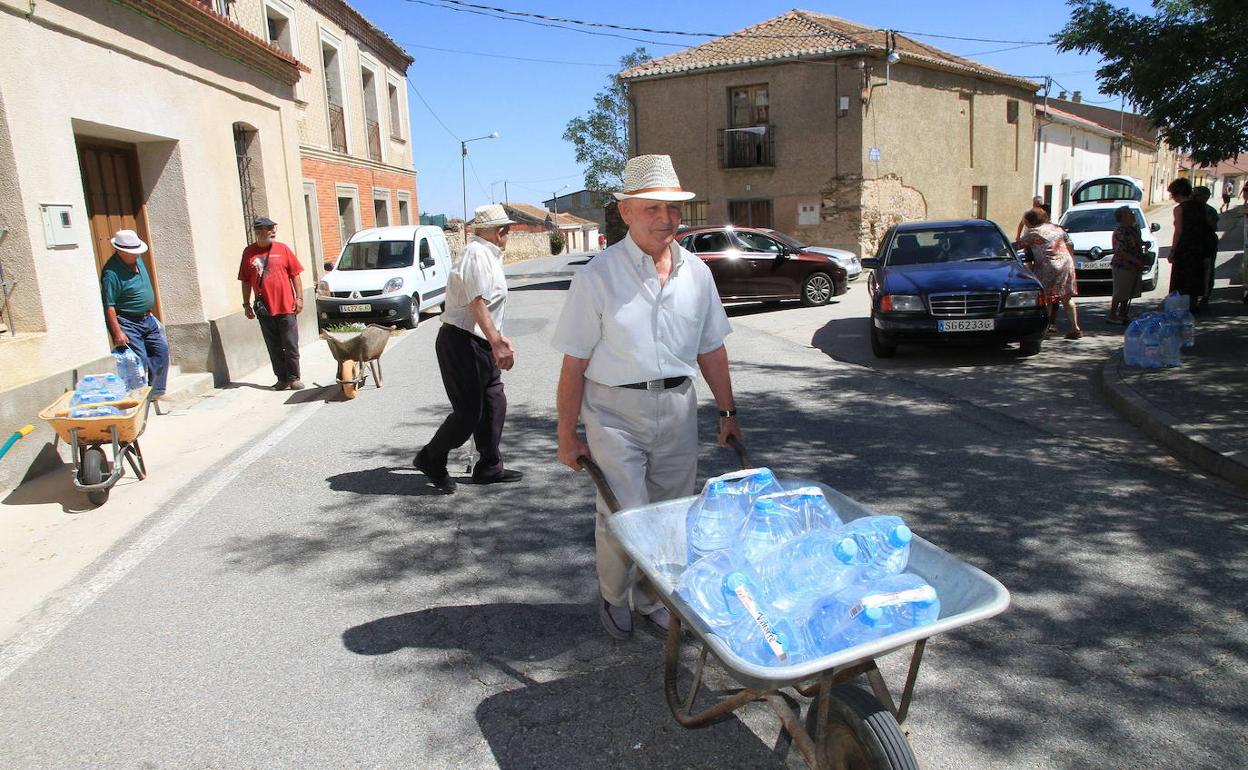 Vecinos de Ochando se aprovisionaban de agua embotellada este verano pasado. 