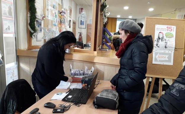 Una madre espera recoger la nueva tarjeta de bus tras realizar el trámite el mes pasado. 