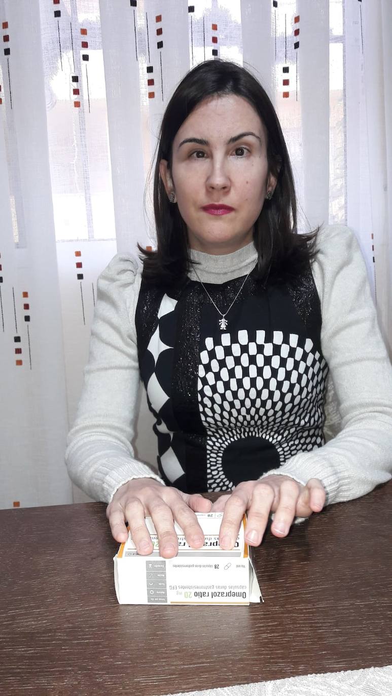 Lidia Aguilar, lee la etiqueta en braille de un medicamento. 