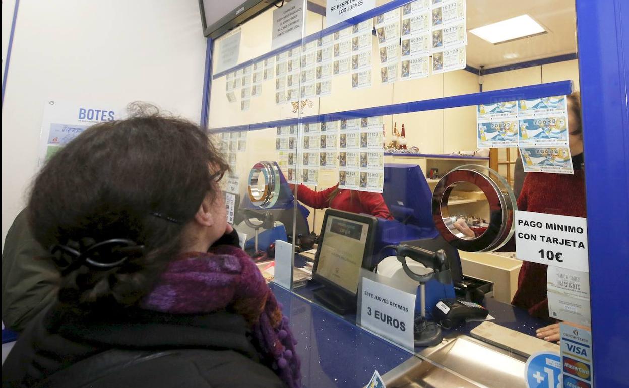 Una clienta mira los décimos antes de comprar. 