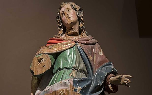 Talla de San Juan Evangelista, llegada al museo en 1941, muestra las huellas de hachazos sobre su garganta y daños en el rostro producidos durante episodios iconoclastas de la Guerra Civil. 