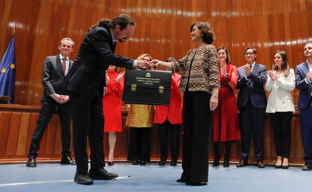 Pablo Iglesias recibe su cartera como nuevo vicepresidente de Asuntos Sociales y Agenda 2030 de manos de Carmen Calvo.