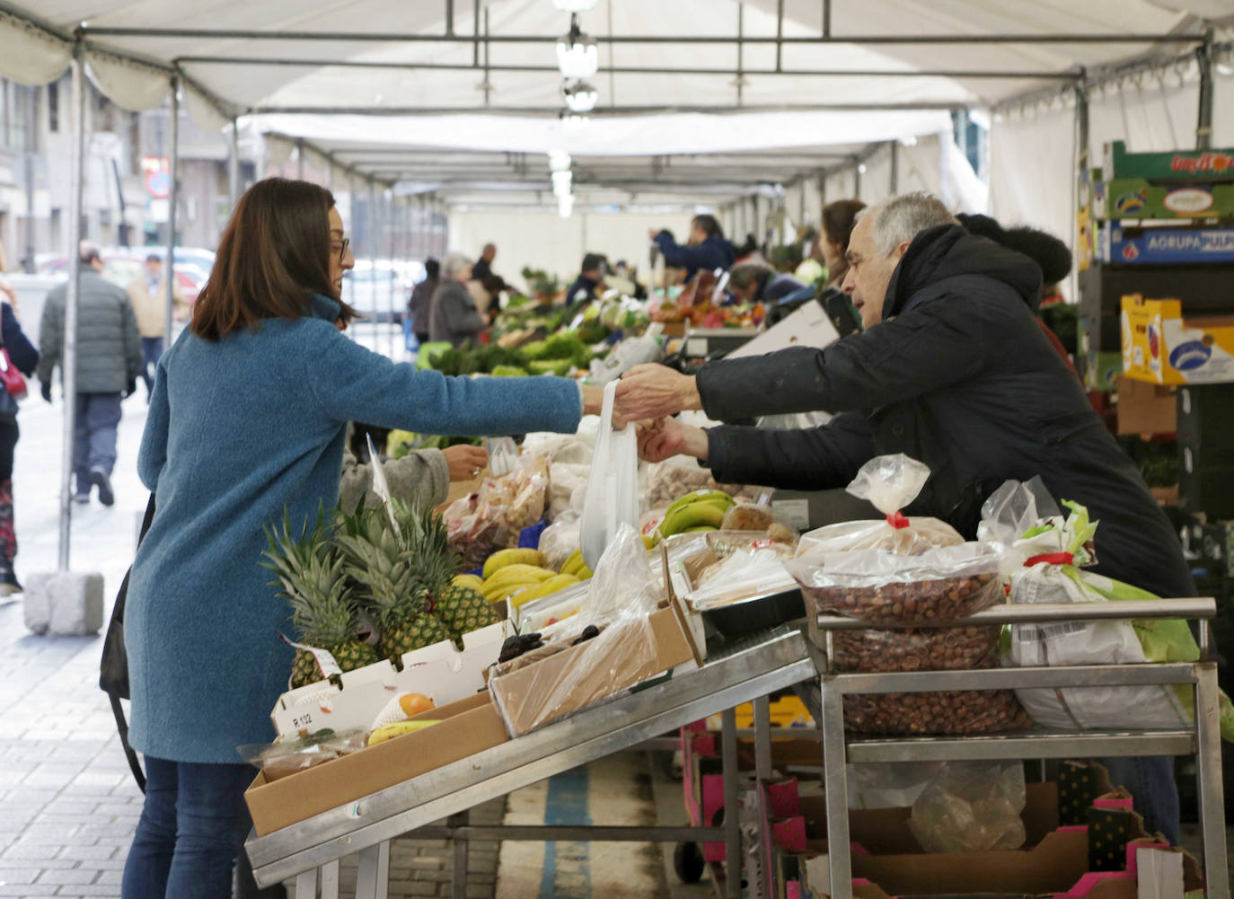 Los puestos del mercado de la Marquesina de la plaza de España se han trasladado hoy, y allí permanecerán durante las próximas cuatro semanas, a la calle Muro, donde se han habilitado carpas sobre el espacio de aparcamiento para vehículos más próximo a la plaza de Madrid.