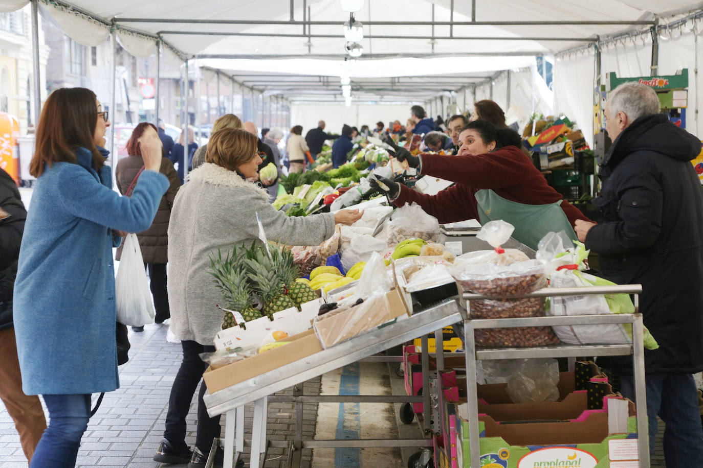 Los puestos del mercado de la Marquesina de la plaza de España se han trasladado hoy, y allí permanecerán durante las próximas cuatro semanas, a la calle Muro, donde se han habilitado carpas sobre el espacio de aparcamiento para vehículos más próximo a la plaza de Madrid.