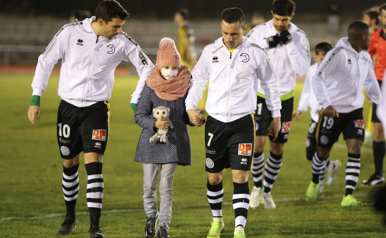 María salta al terreno de juego con Carlos de la Nava y Piojo. 