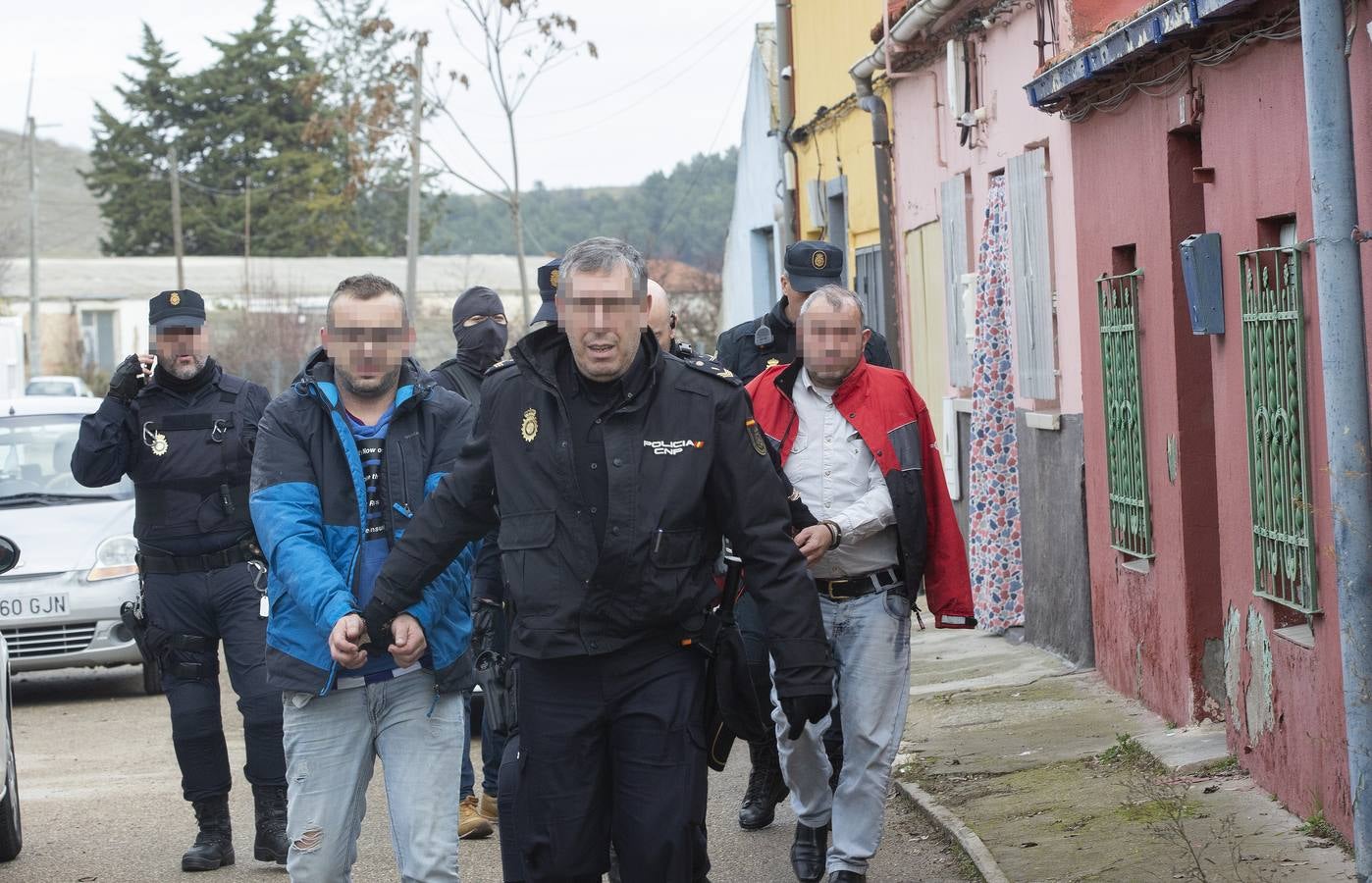 Los policías nacionales trasladan a dos de los detenidos de la vivienda de la calle Panera (La Victoria), en la que se intervinieron los tres kilos de 'speed'.