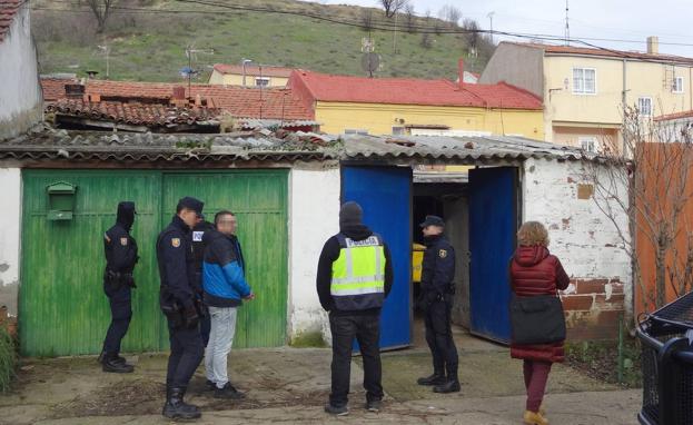 Los agentes registran el patio trasero de la vivienda de la calle Panera ante uno de los arrestados.