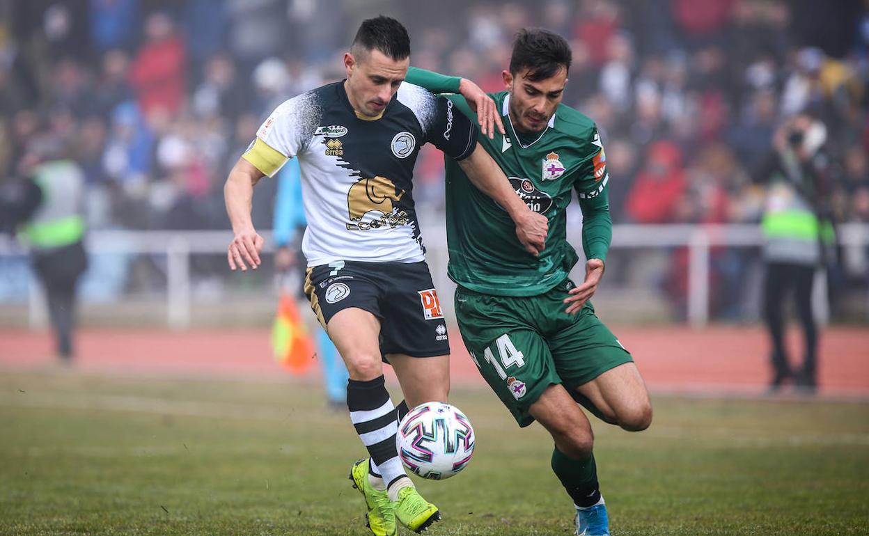 Piojo, capitán de Unionistas, pugna con un rival del Deportivo de LaCoruña.