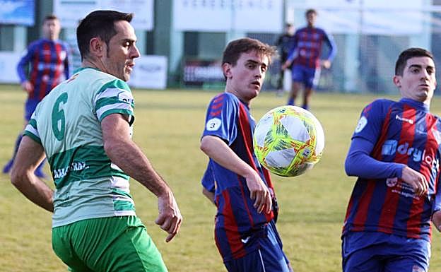 Porfirio despeja el balón ante Elías e Ivi. 