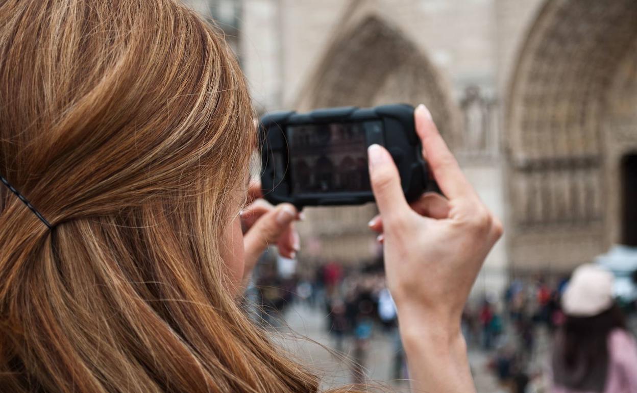 Turista con su móvil en París (Francia). 