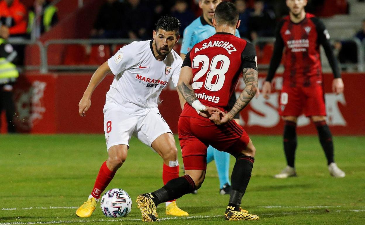 Nolito del sevilla se juega un balón ante Sánchez del Mirandés.