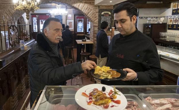 Pablo Martínez Gil atiende a un cliente en la barra del restaurante La Criolla. 