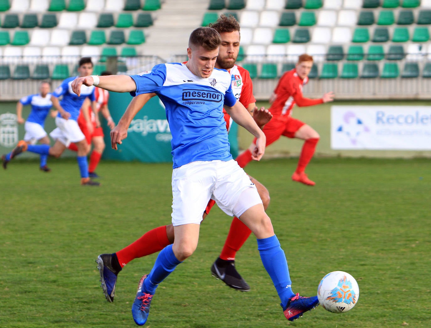 Josete avanza con el balón perseguido por un defensa rival.