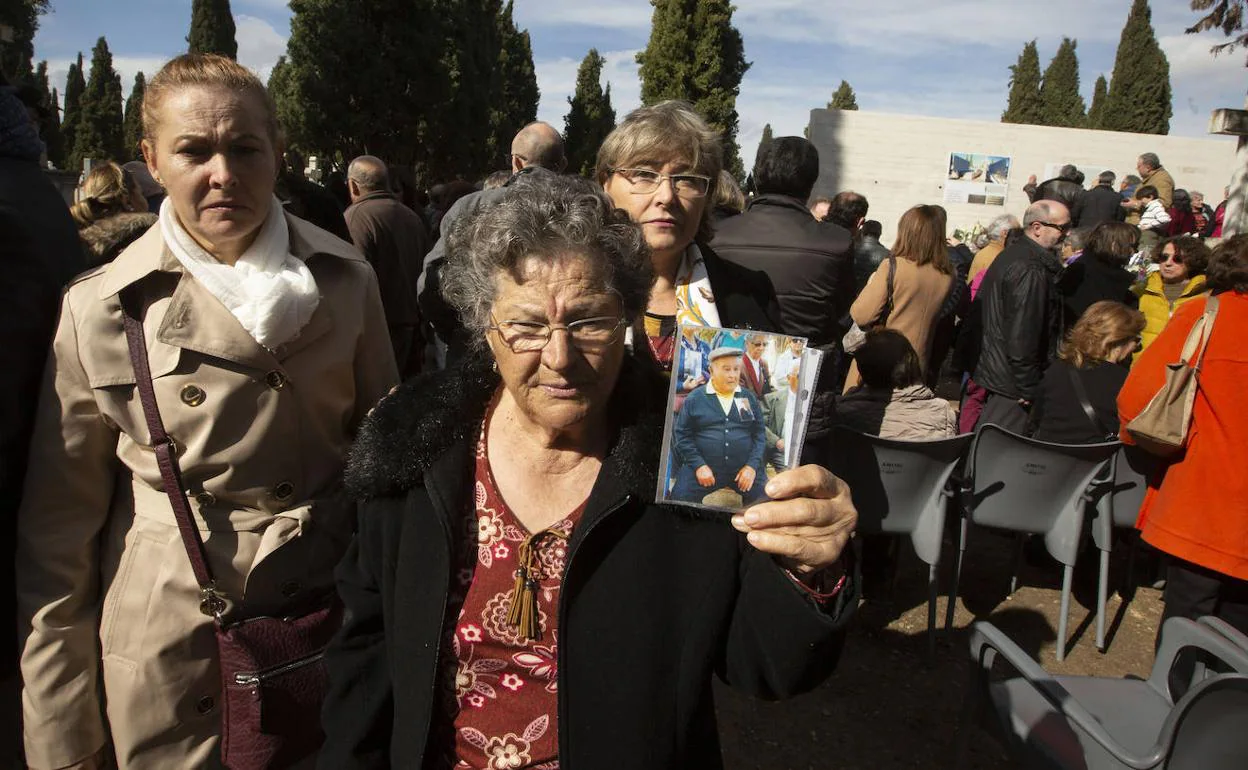 Evarista, la mujer de Vitorio, muestra la foto de su marido y de su suegro con sus hijas María Ángeles y María Antonia, detrás, durante el acto celebrado ayer en el cementerio El Carmen de Valladolid. 