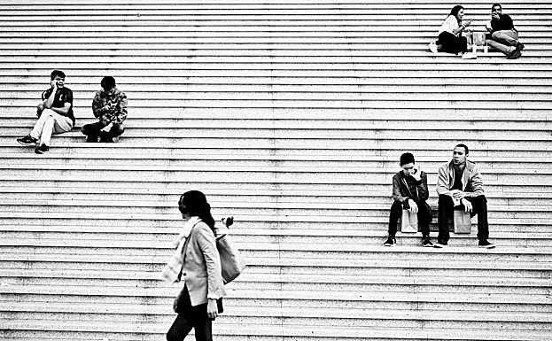 Ciudadanos sentados en la escaleras delArco de la Defensa. 