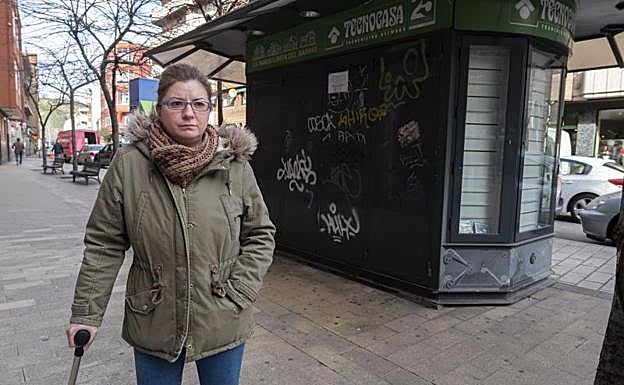 Laura de la Fuente, con muletas, ante su quiosco, ahora cerrado, de la calle Dársena.