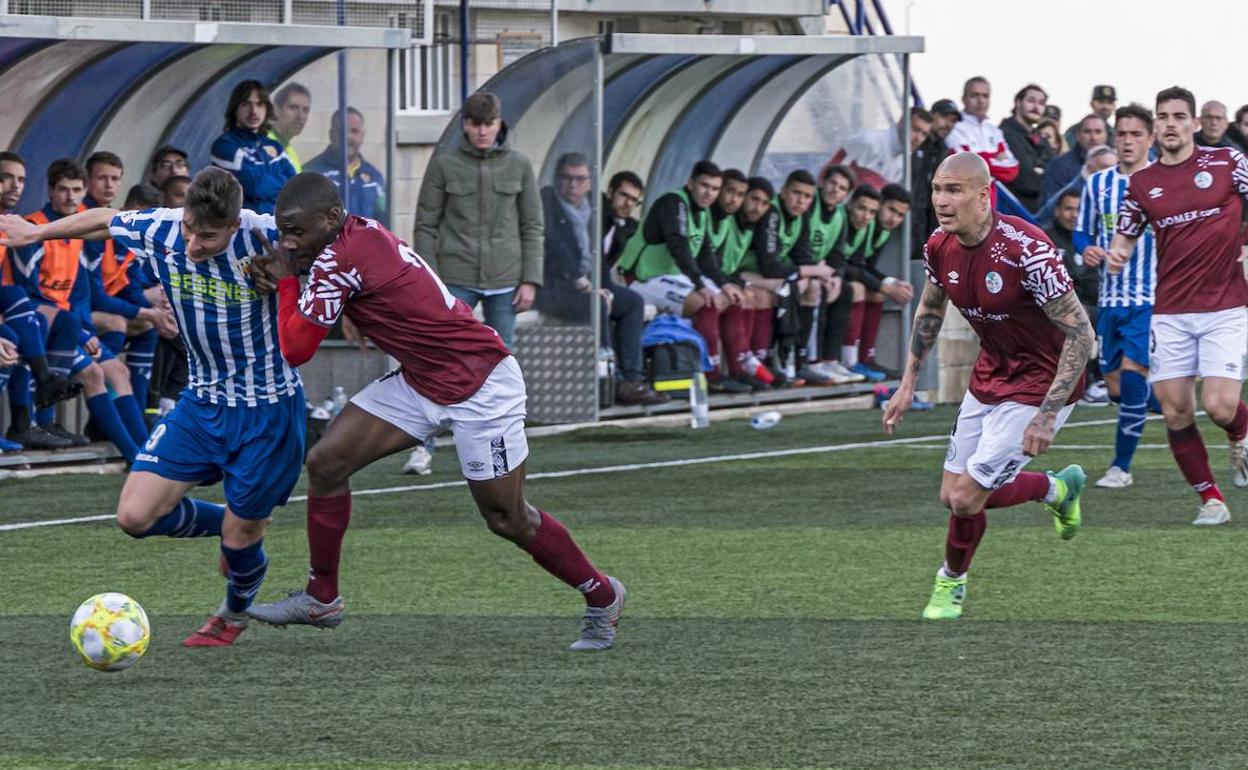 Aldo One trata de frenar el avance de un jugador del Izarra. 