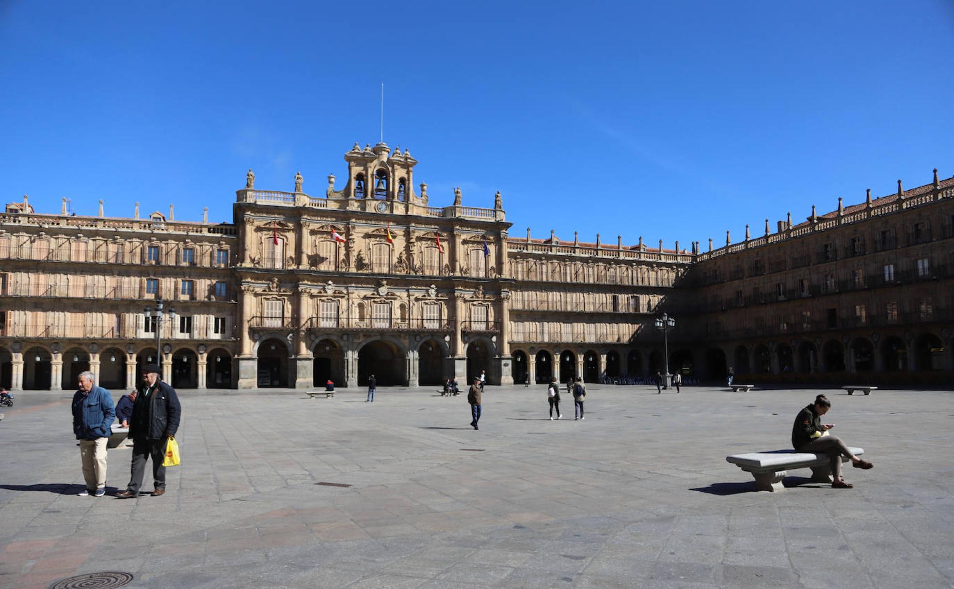 Algunos viandantes pasean por una Plaza Mayor vacía durante la mañana de ayer.