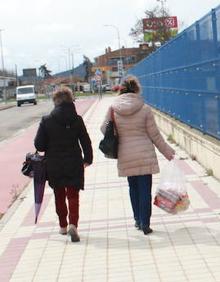 Imagen secundaria 2 - Una trabajadora del Lupa de Venta de Baños repone naranjas. Dos trabajadoras de Siro salen de trabajar con productos de la empresa para su consumo. 
