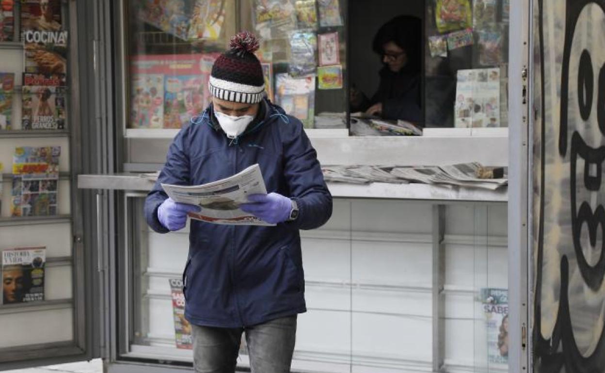 Un hombre compra la prensa. 