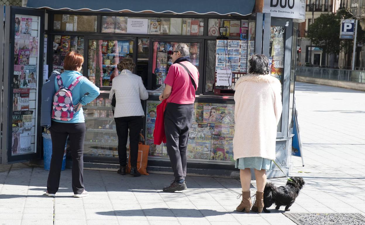 Quiosqueros atendiendo a clientes que guardan la cola con la distancia de seguridad, un ejemplo de cuando se hacen bien las cosas