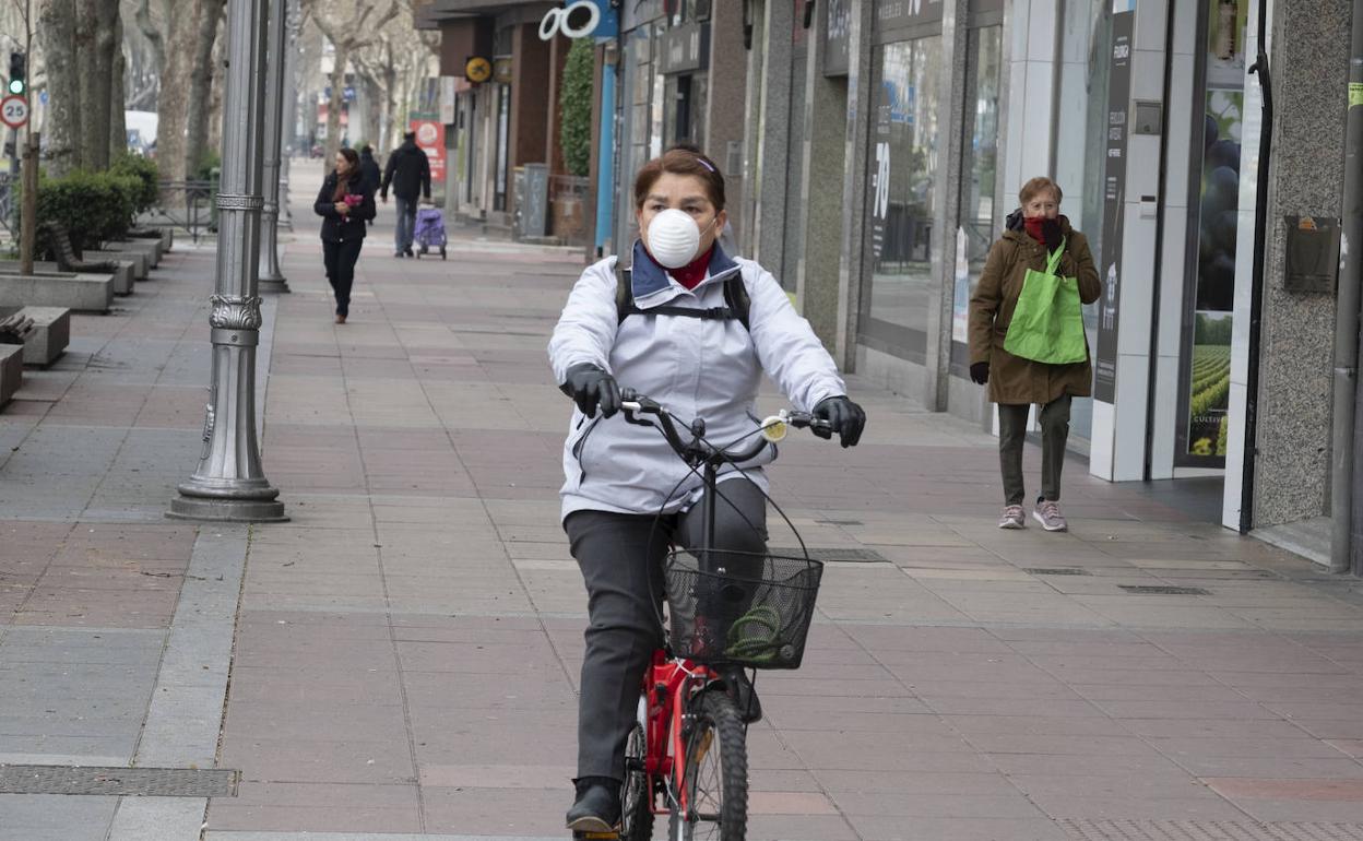 Una mujer circula en bicicleta y con mascarilla por el Paseo de Zorrilla de Valladolid. 