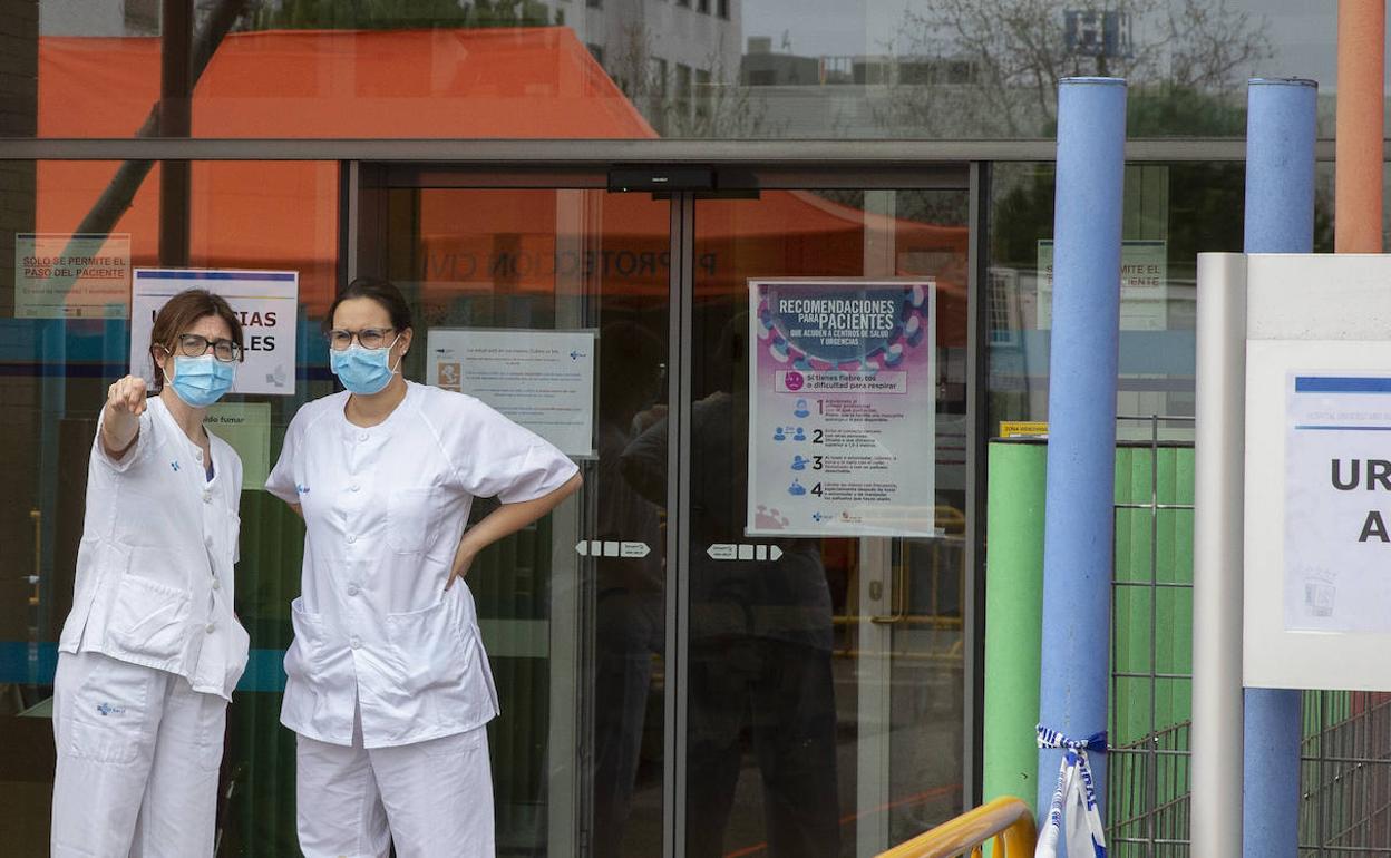 Dos miembros del personal sanitario del Río Hortega, en la puerta de Urgencias. 